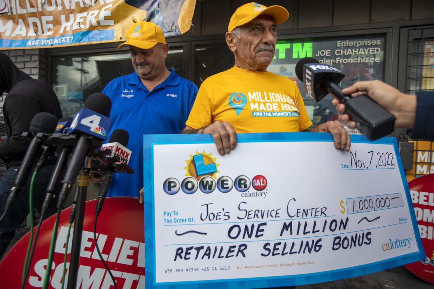 Joe Chahayed, (CH) middle, holds up a check for 1,000,000. For the retailer selling bonus at Joes Service Center on Tuesday, Nov. 8, 2022, in Altadena, CA.
