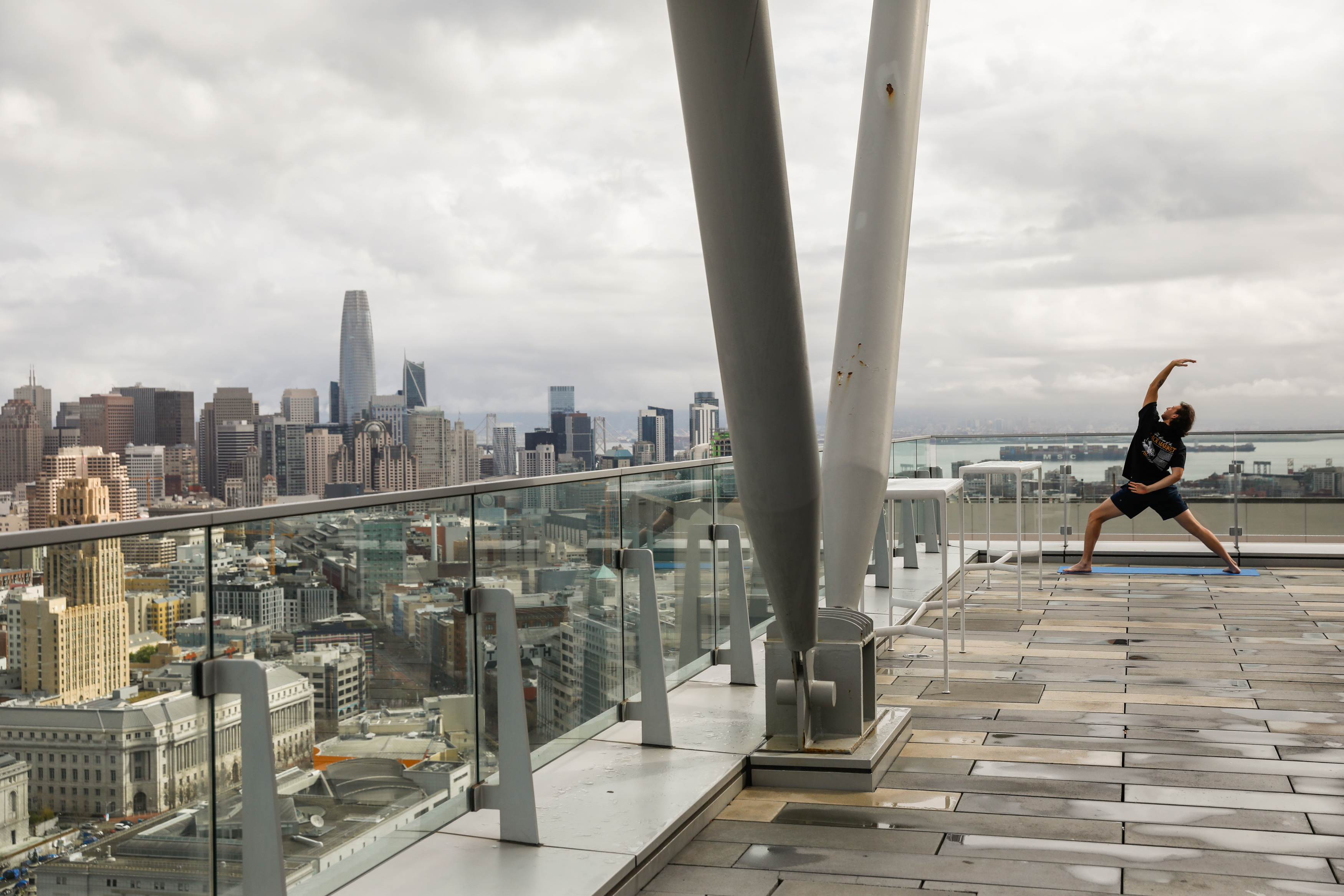 Resident Emmet Dettweiler does yoga on the roof of the 100 Van Ness apartment building, the largest office to housing conversion in San Francisco.