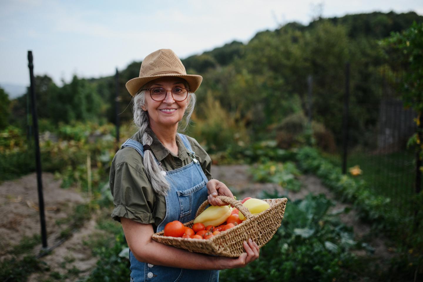 An elderly woman holding vegetables.