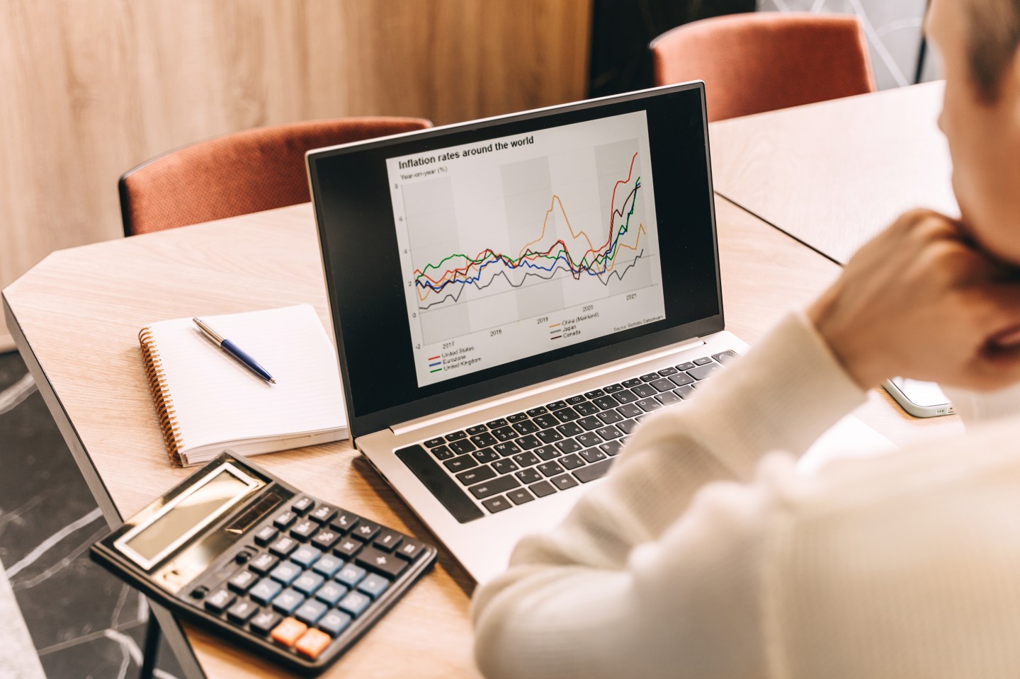 Businessman work in cafe with laptop. Inflation chart on the screen.