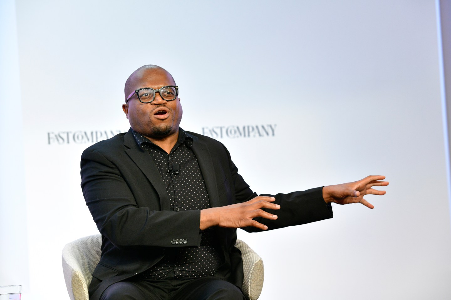 Jamal Watkins speaks on a panel on stage at an event.
