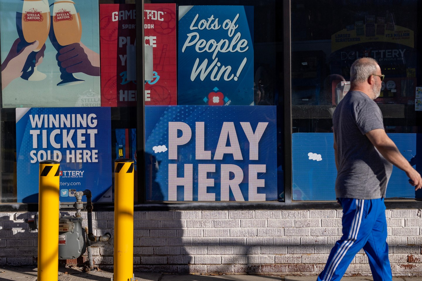 A man walks by a store selling lottery tickets