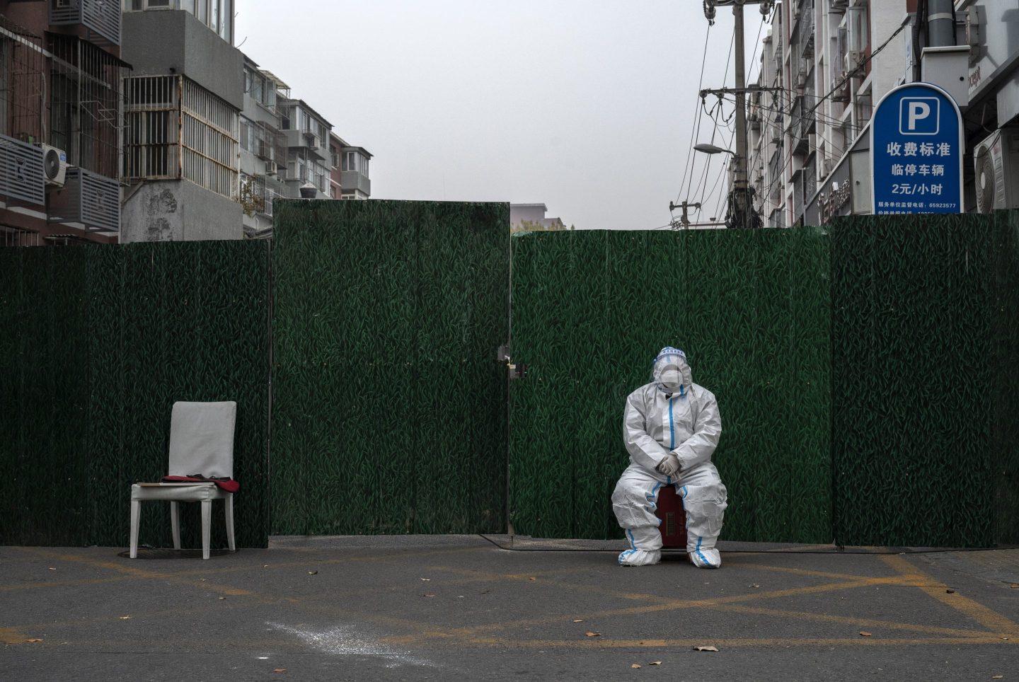 An epidemic control worker guards an area under lockdown to prevent the spread of COVID-19 on Thursday in Beijing, China.
