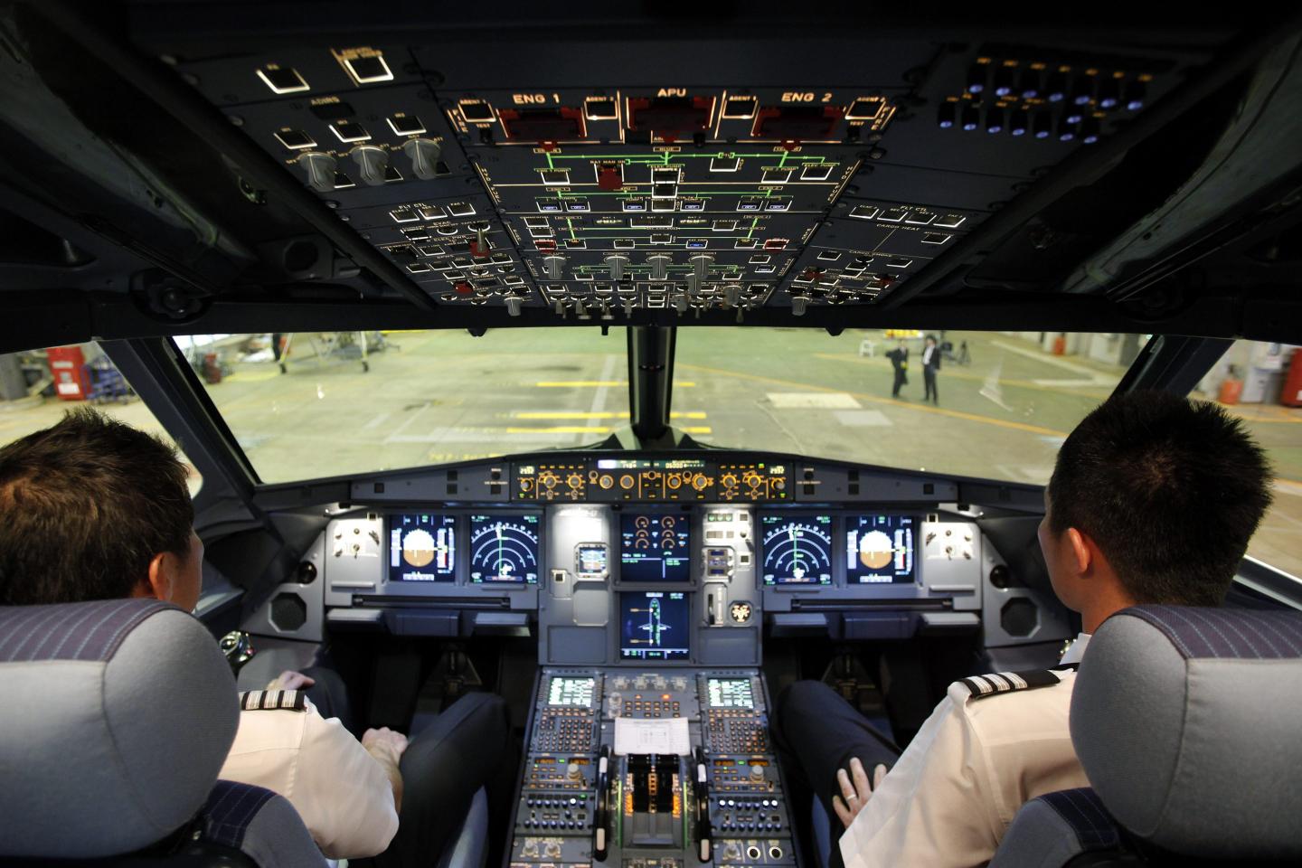 Pilots sit in the cockpit of Jetstar Japan Co.'s Airbus SAS A320 aircraft