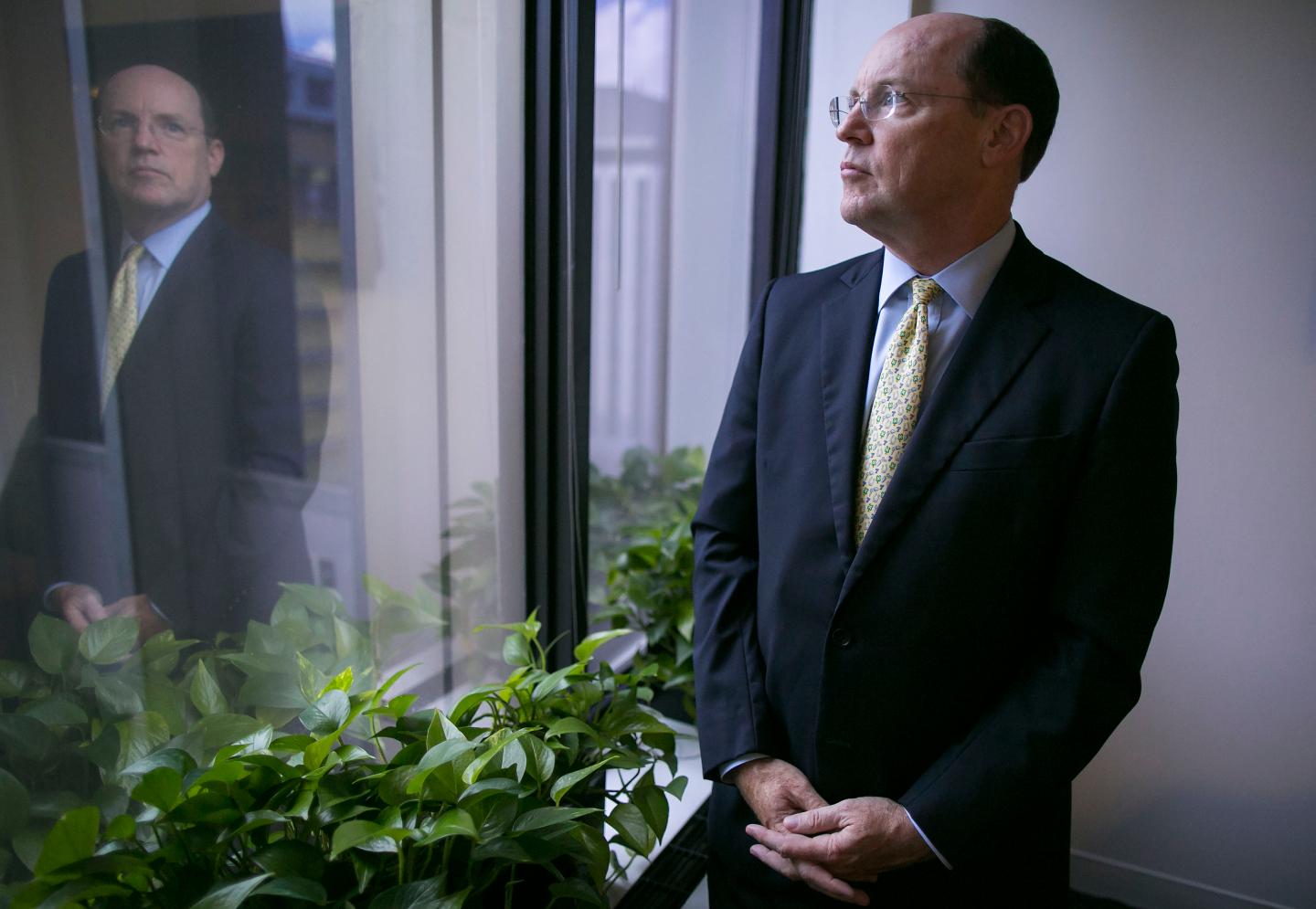 Shot of David Kelleher, CEO of Better Markets, standing in his office looking out a window