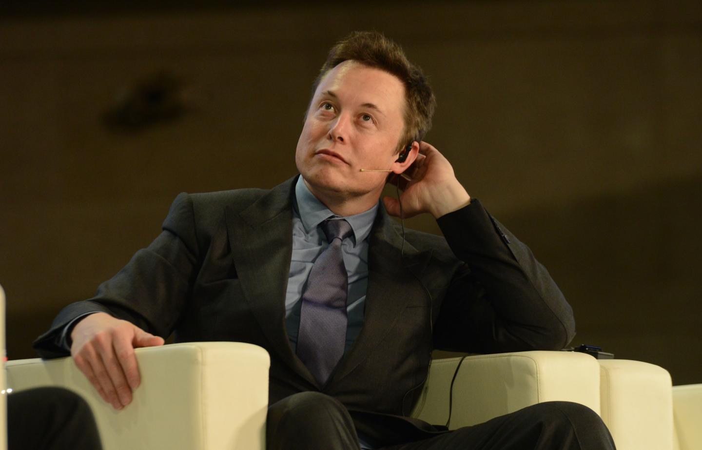 Elon Musk sitting on stage during a 2014 conference in Beijing