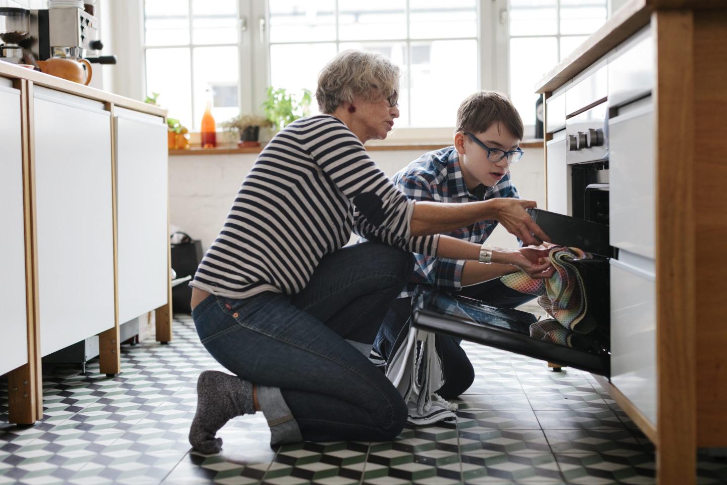 Mature Mother teaching her teenage Son how to bake