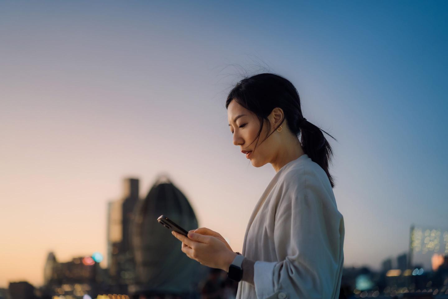 A young woman looks at her smart phone