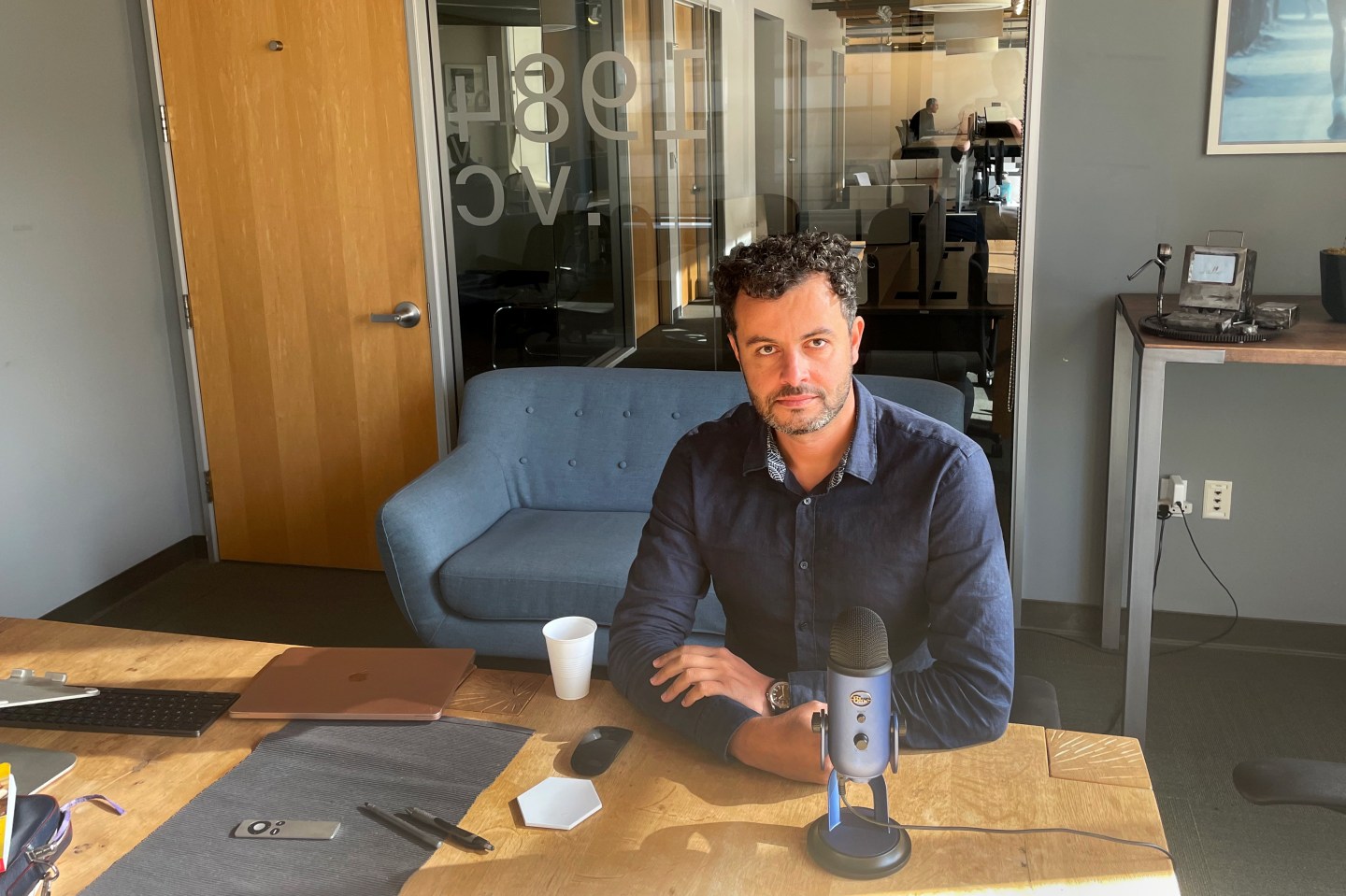 Ramy Adeeb sitting at desk in 1984 VC offices.