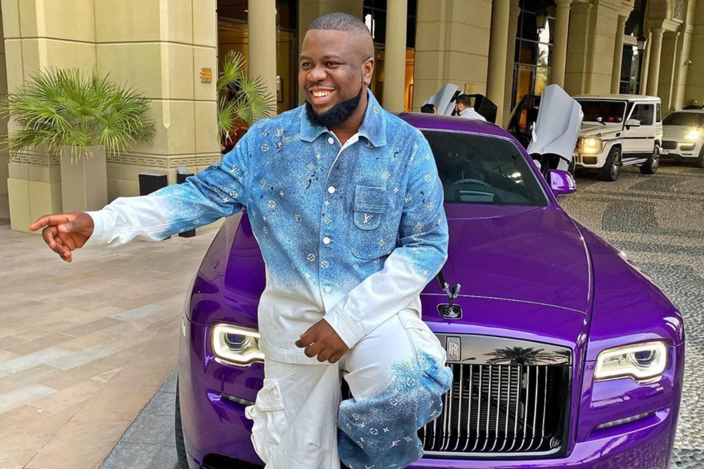 Instagram influencer Ray Hushpuppi sits on purple car