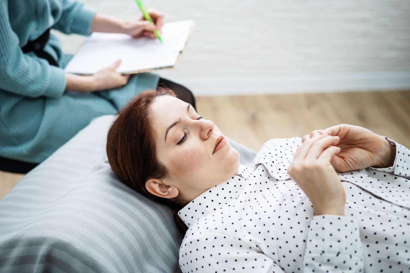 Woman Lies On A Couch And Expresses Her Feelings, While A Psychologist Makes Notes On A Tablet.
