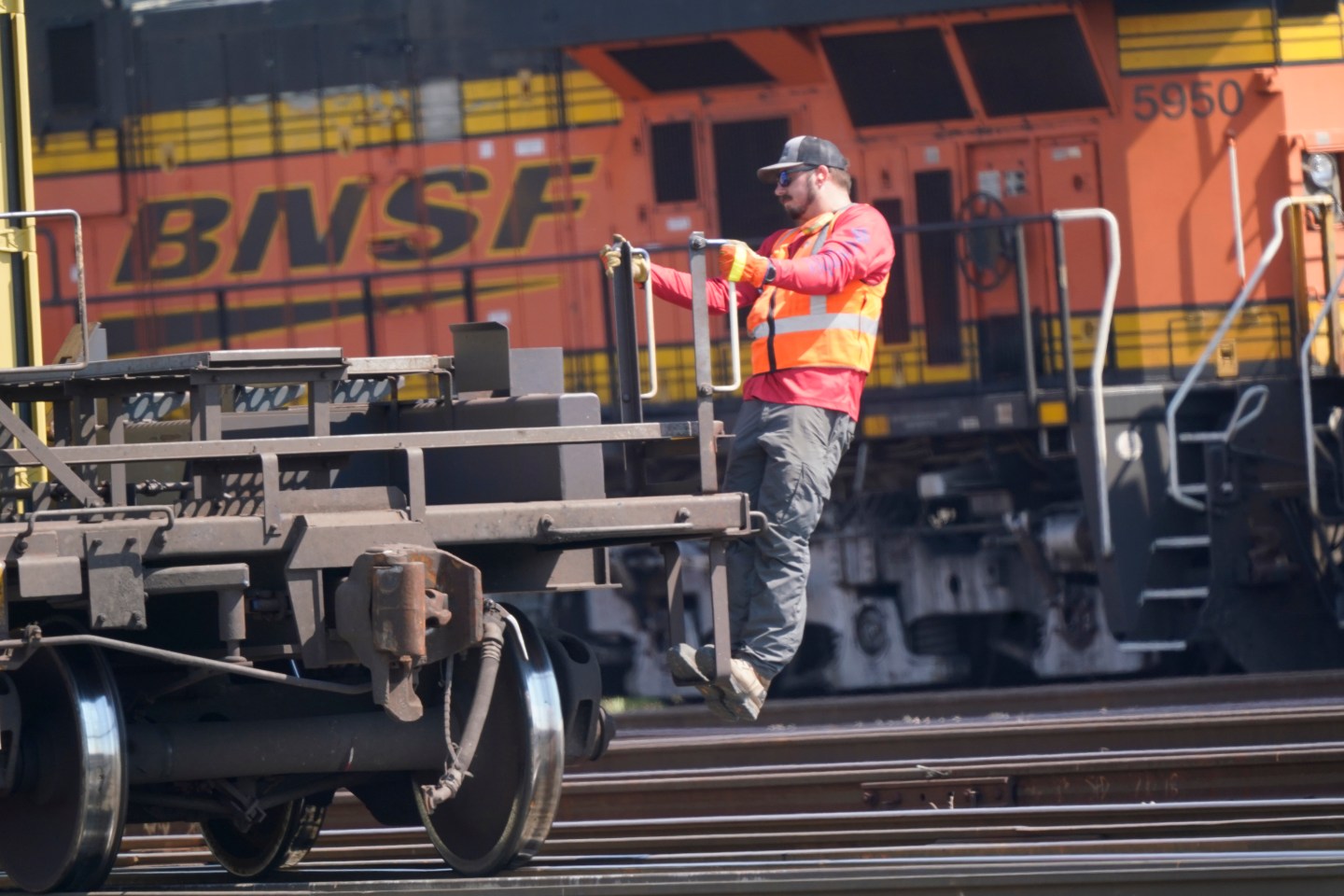 A worker rides a rail car at a BNSF rail crossing in Saginaw, Texas, on Sept. 14, 2022.