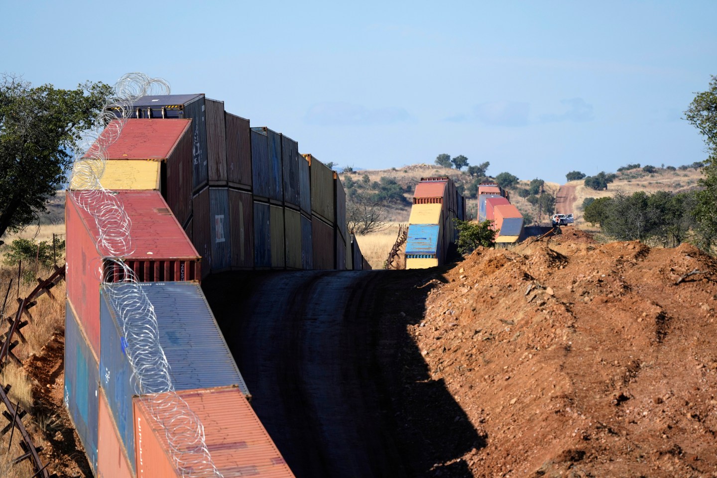 A long row of double-stacked shipping containers provide a new wall between the United States and Mexico in the remote section area of San Rafael Valley, Ariz., Dec. 8, 2022.