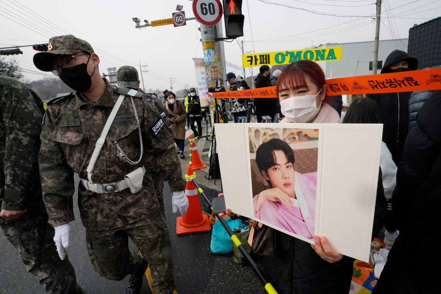A fan waits for K-pop band BTS's member Jin to arrive before he enters the army to serve near an army training center in Yeoncheon, South Korea, Dec. 13, 2022.