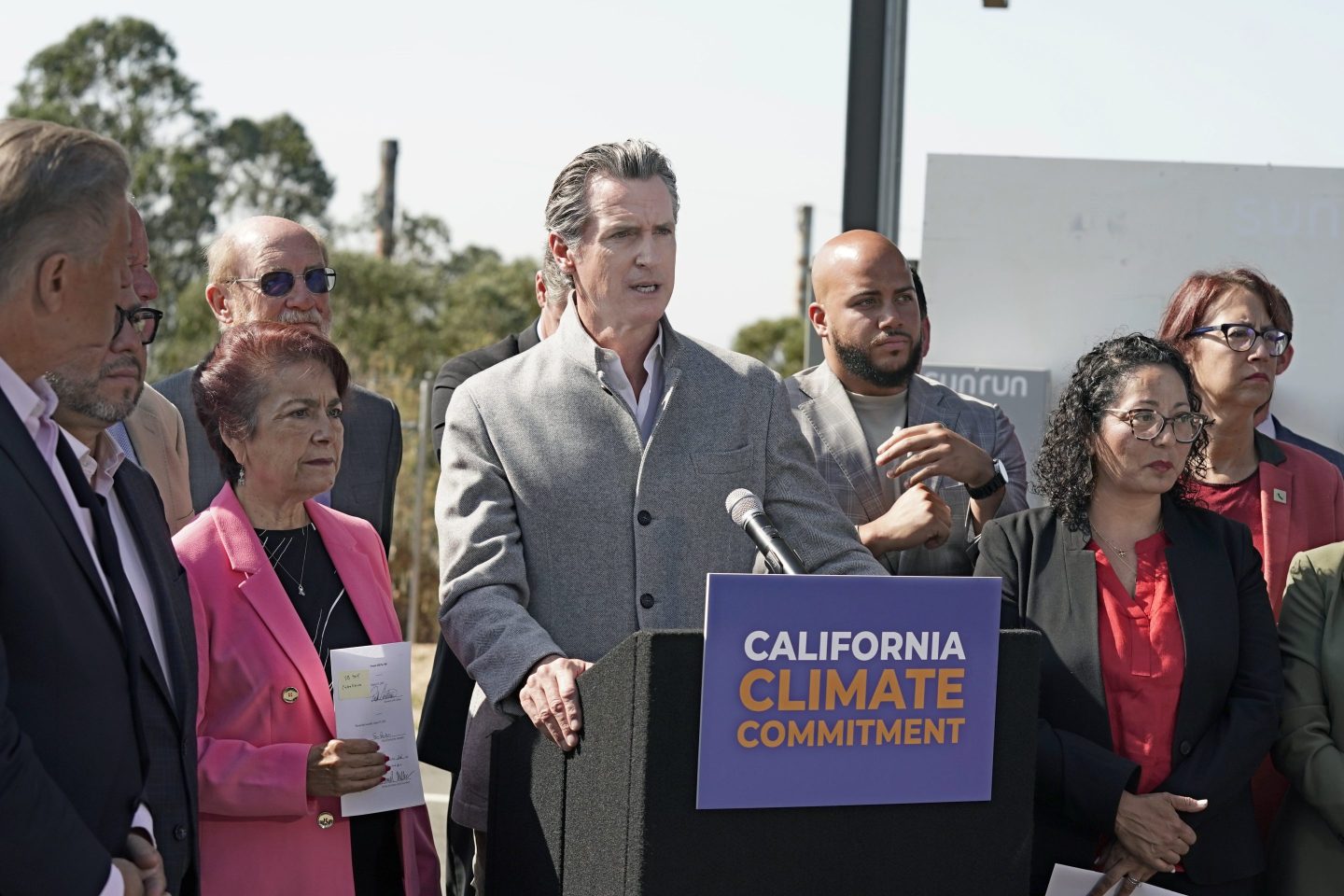 California Governor Gavin Newsome flanked by other politicians in California.