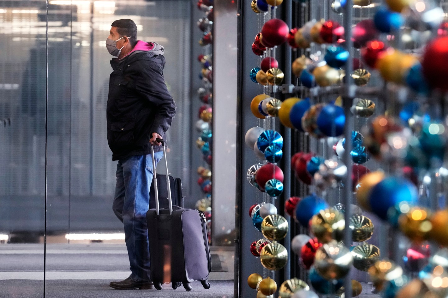 A man with a suitcase at an airport.