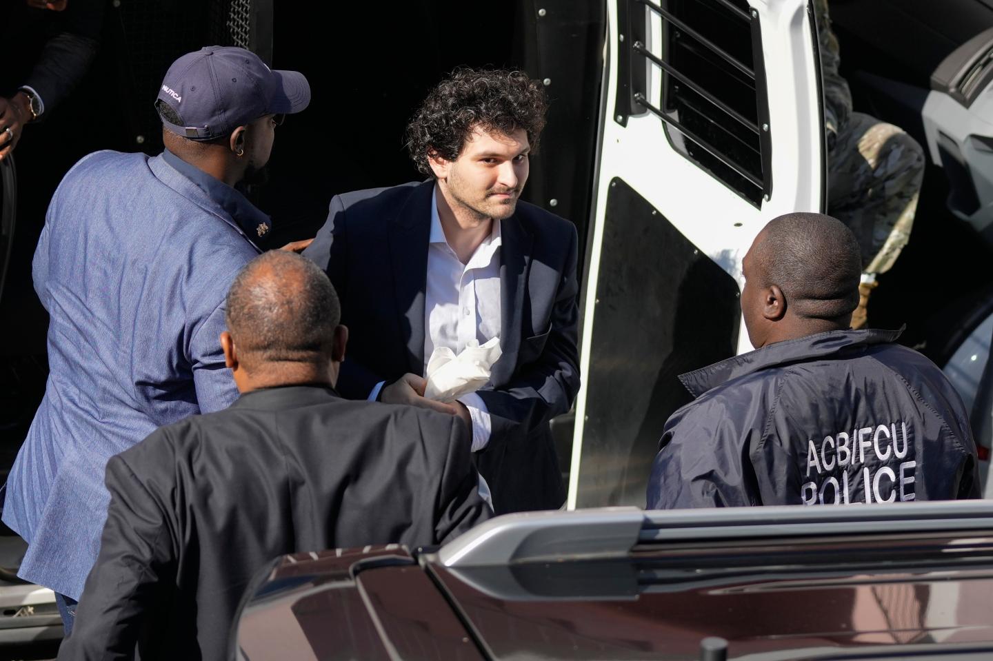 Sam Bankman-Fried in handcuffs.