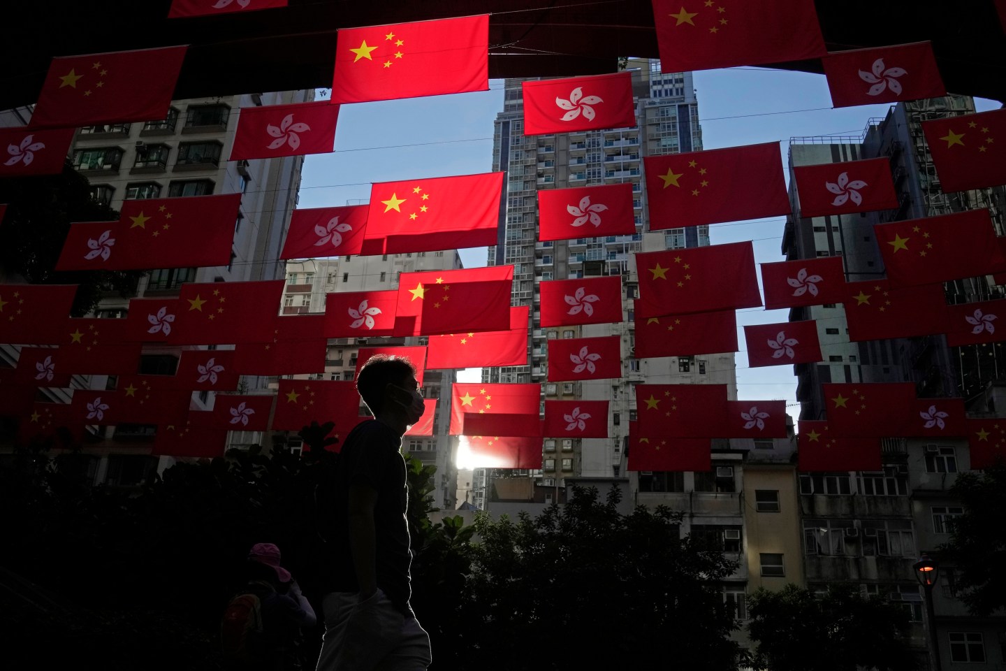 A man walks past Chinese and Hong Kong flags to celebrate the 25th anniversary of Hong Kong handover to China, in Hong Kong, on June 24, 2022.