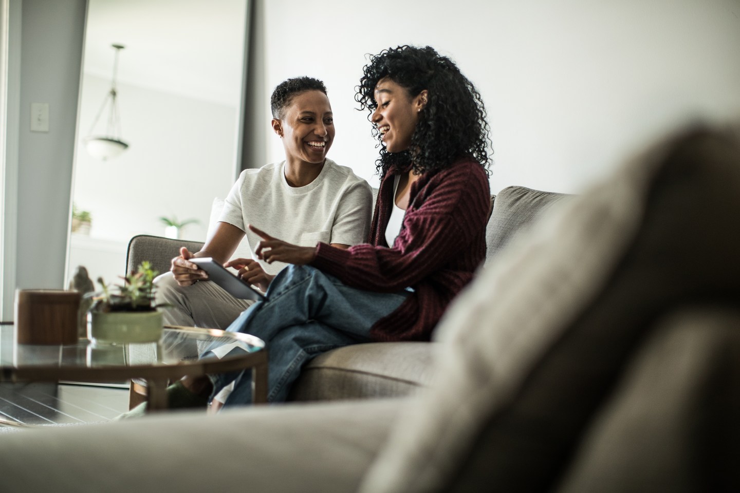 Lesbian couple talking on couch.