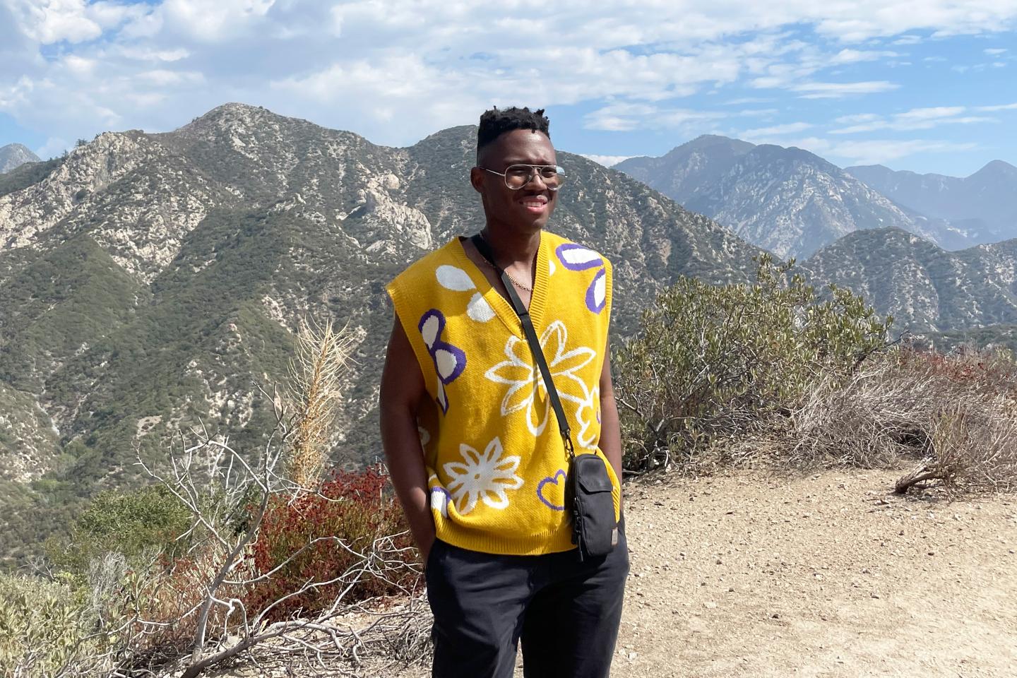 A young man in front of mountain range