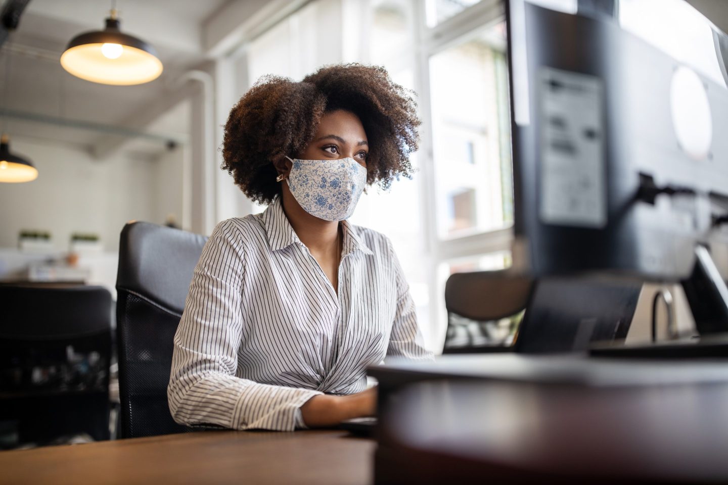 Woman with face mask at office desk