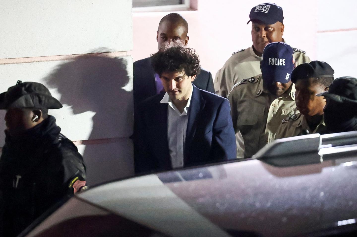 Sam Bankman Fried  is escorted out of the Magistrate Court building after his arrest in Nassau, Bahamas December 13, 2022. 