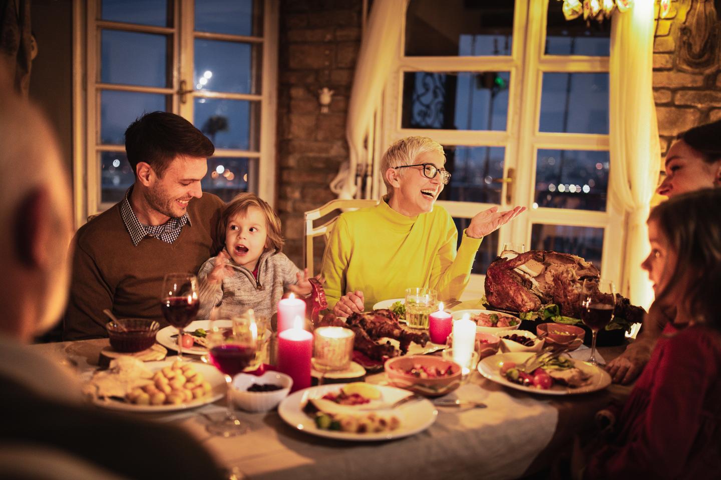 Happy extended family talking during holiday dinner.