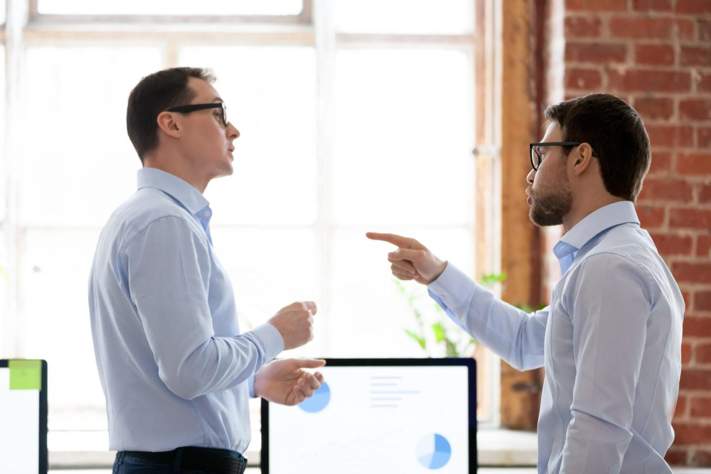 Two male colleagues have a disagreement in the office