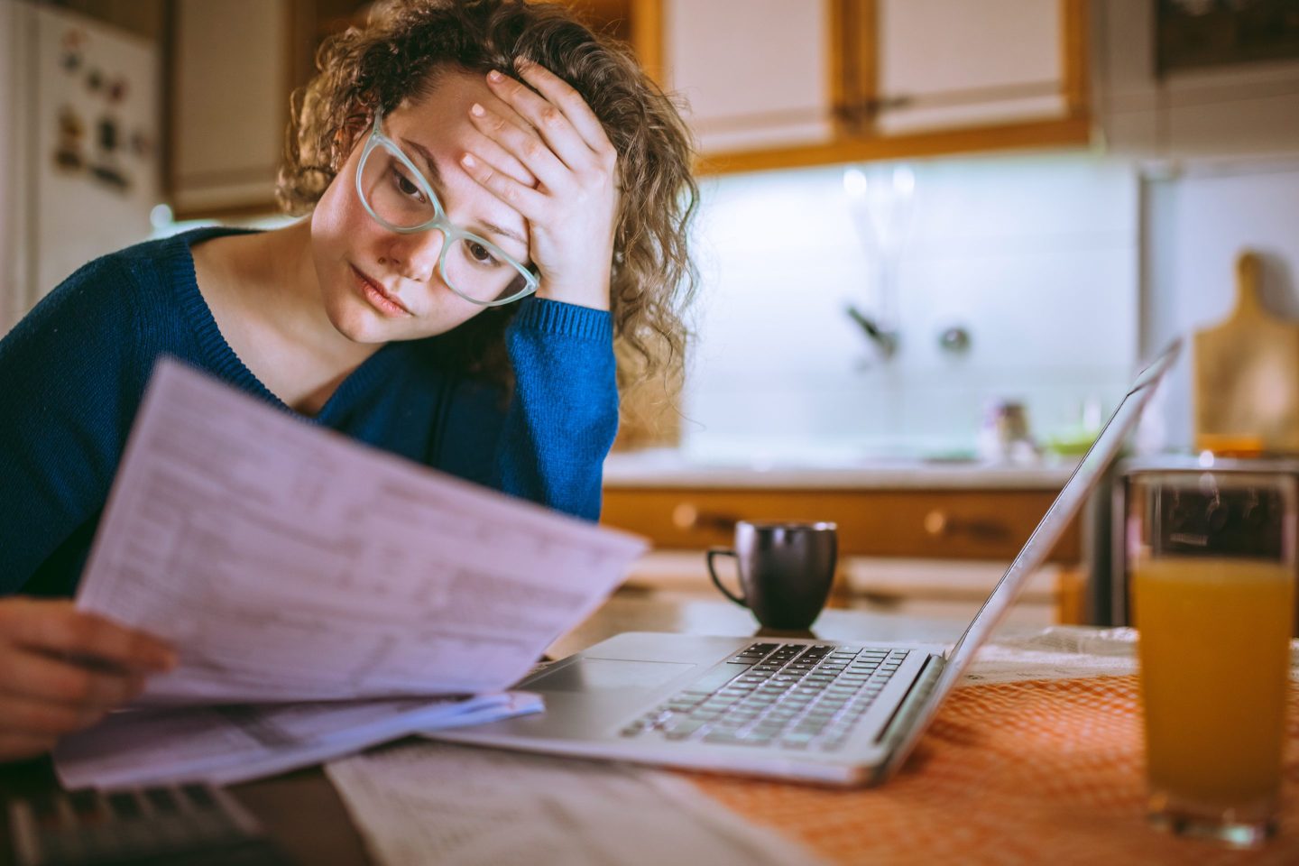 A young woman paying kitchen table at desk