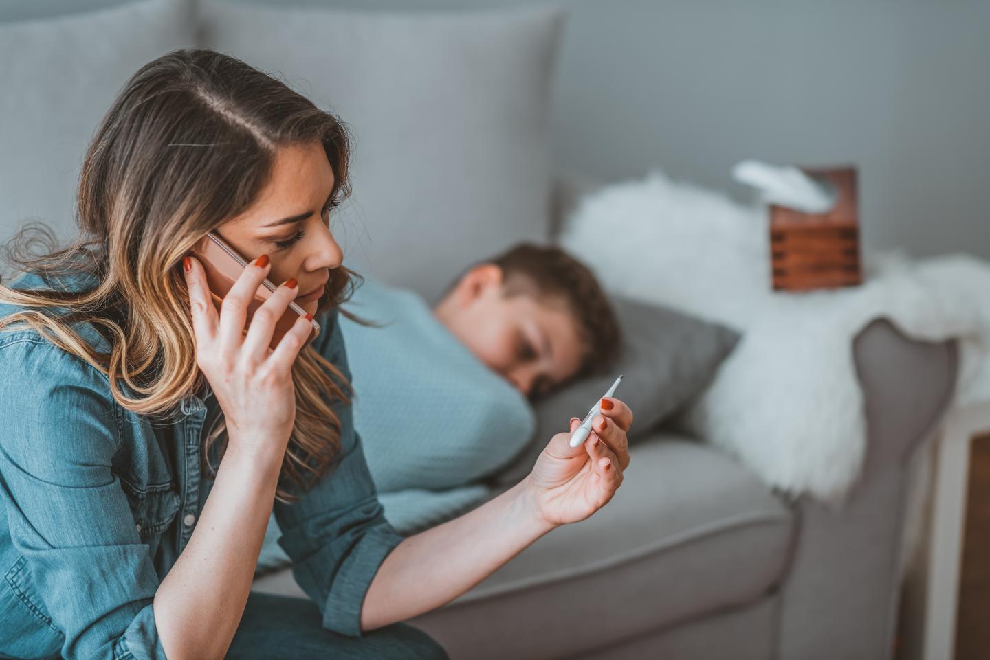 Woman taking the temperature of a sick child