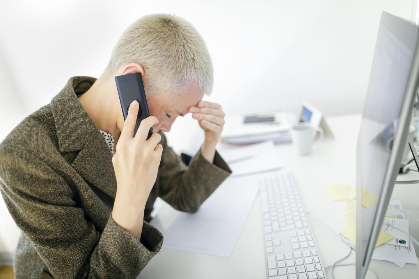 Photo of an employee looking stressed at work.
