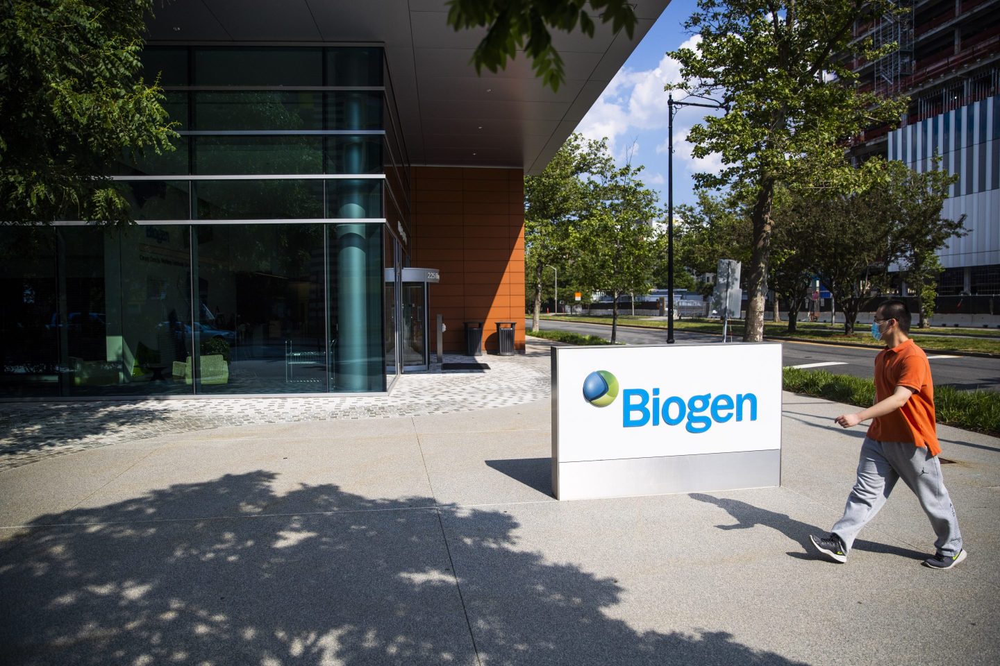 A pedestrian walks by Biogen's headquarters