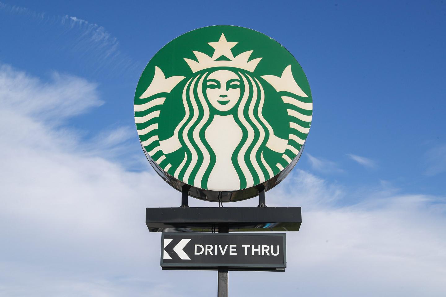 A Starbucks sign against the blue sky.