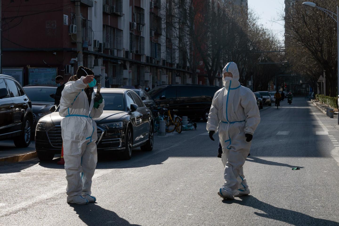 Two health workers in white protective gear in Beijing