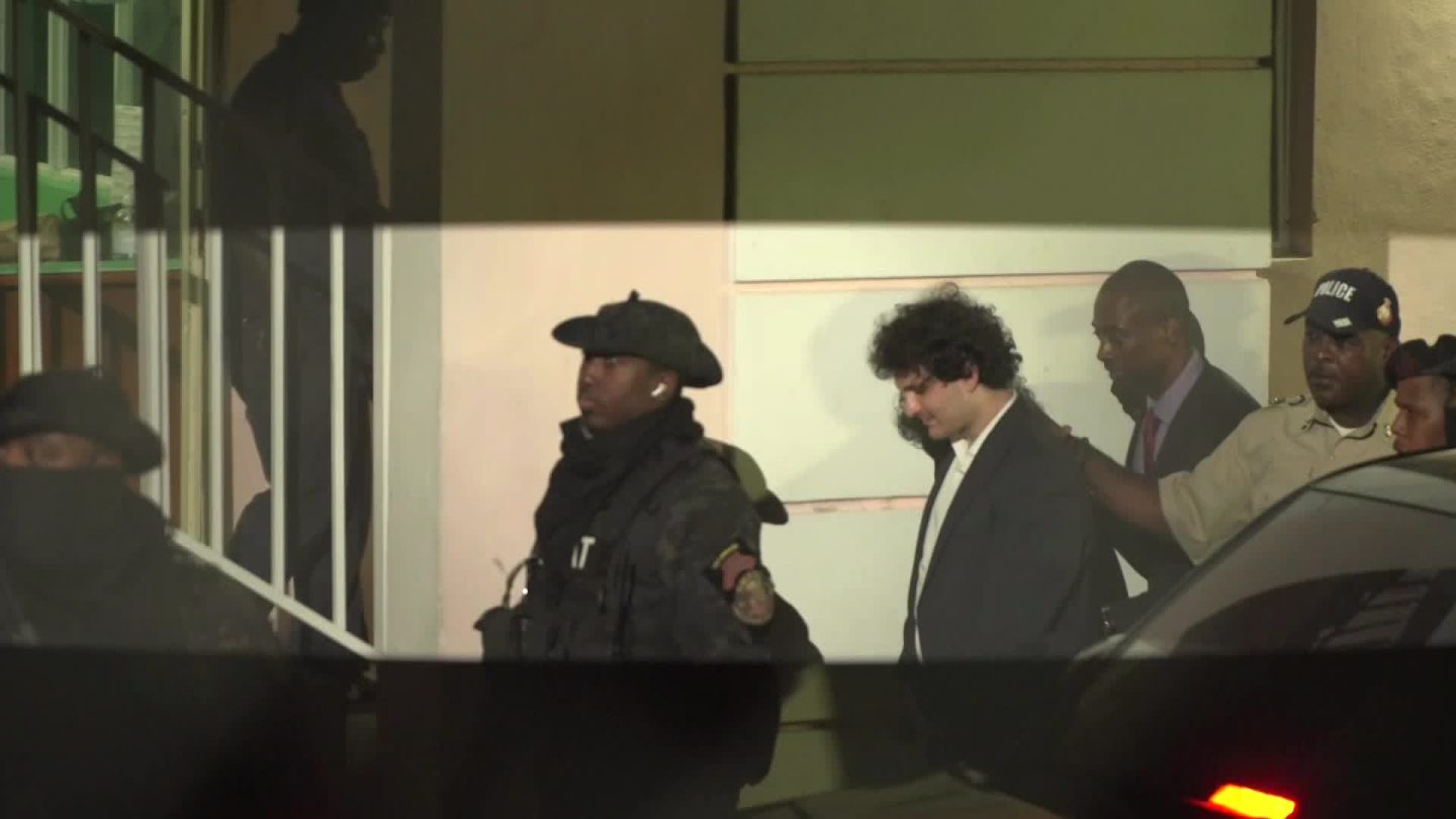 Sam Bankman-Fried, founder of FTX, center right, is escorted out of the Magistrate's Court in Nassau, Bahamas