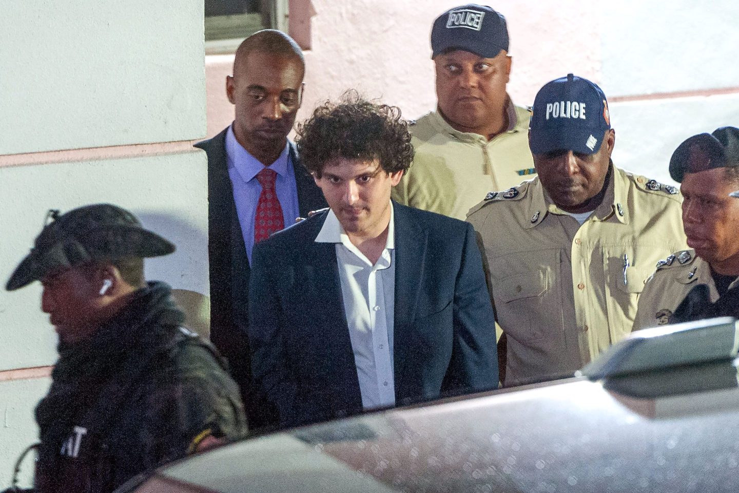 FTX founder Sam Bankman-Fried is led away in handcuffs by officers of the Royal Bahamas Police Force in Nassau, Bahamas, on Dec. 13.