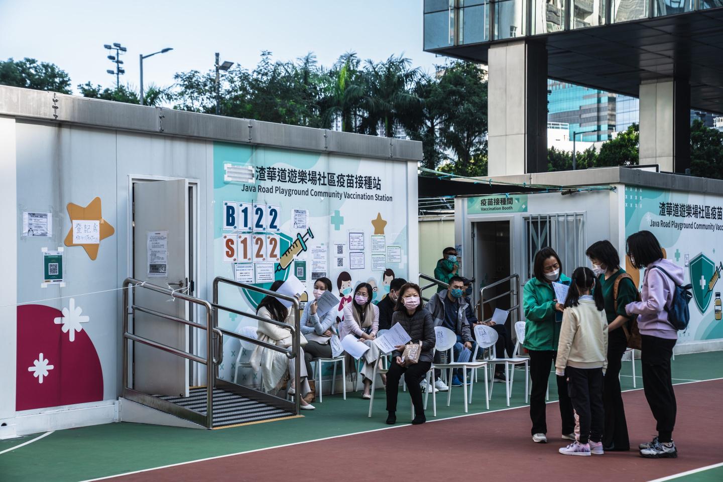 People in Hong Kong wait at a COVID vaccination center