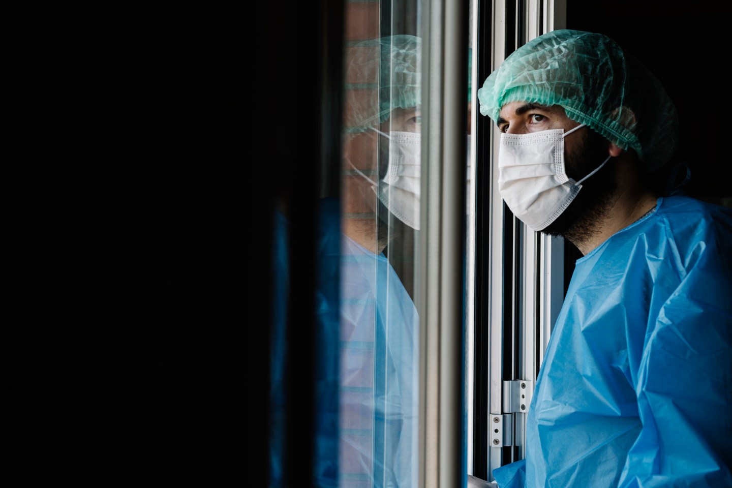 A doctor looking through a window.