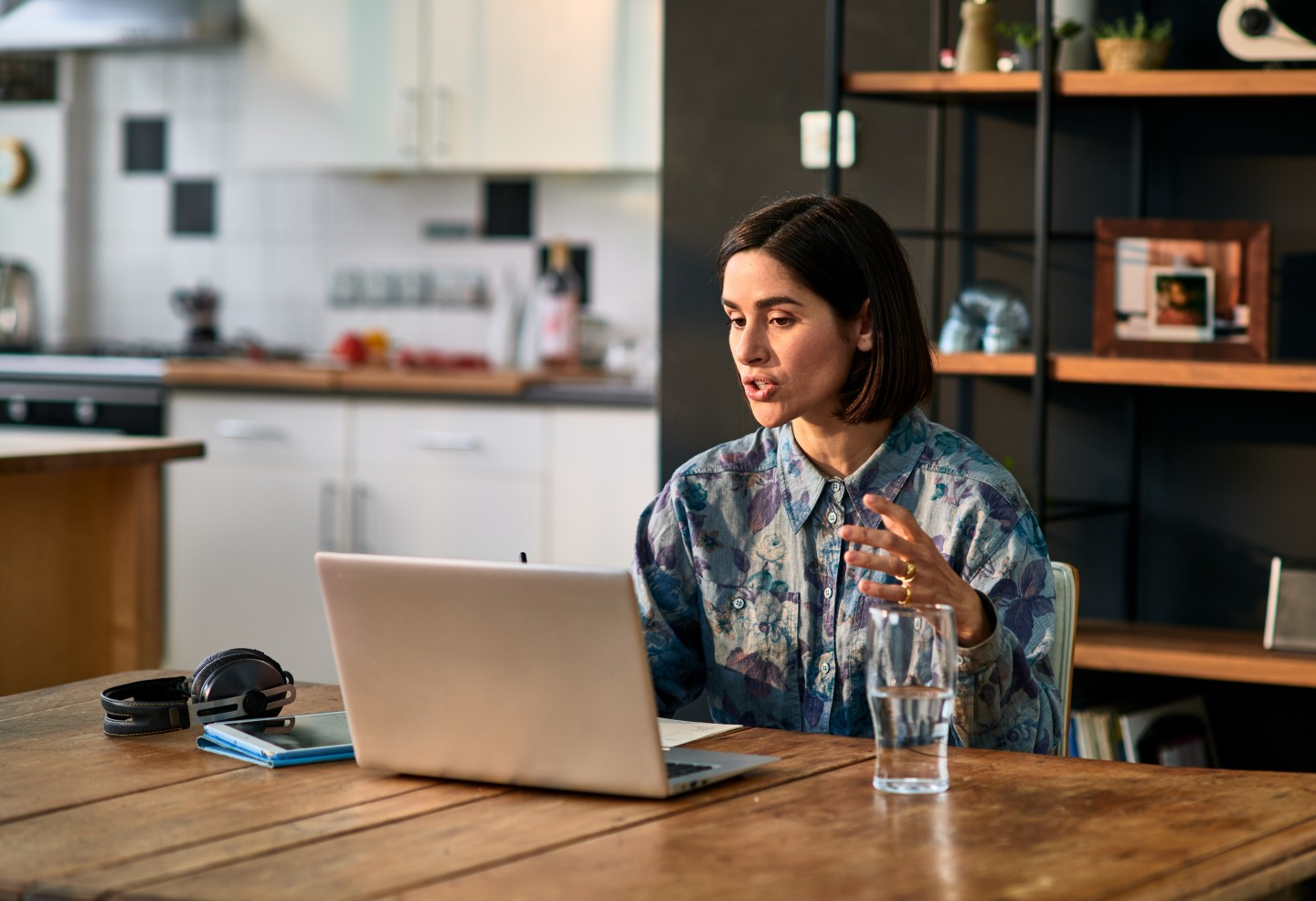 A woman working remotely on her laptop in a kitchen