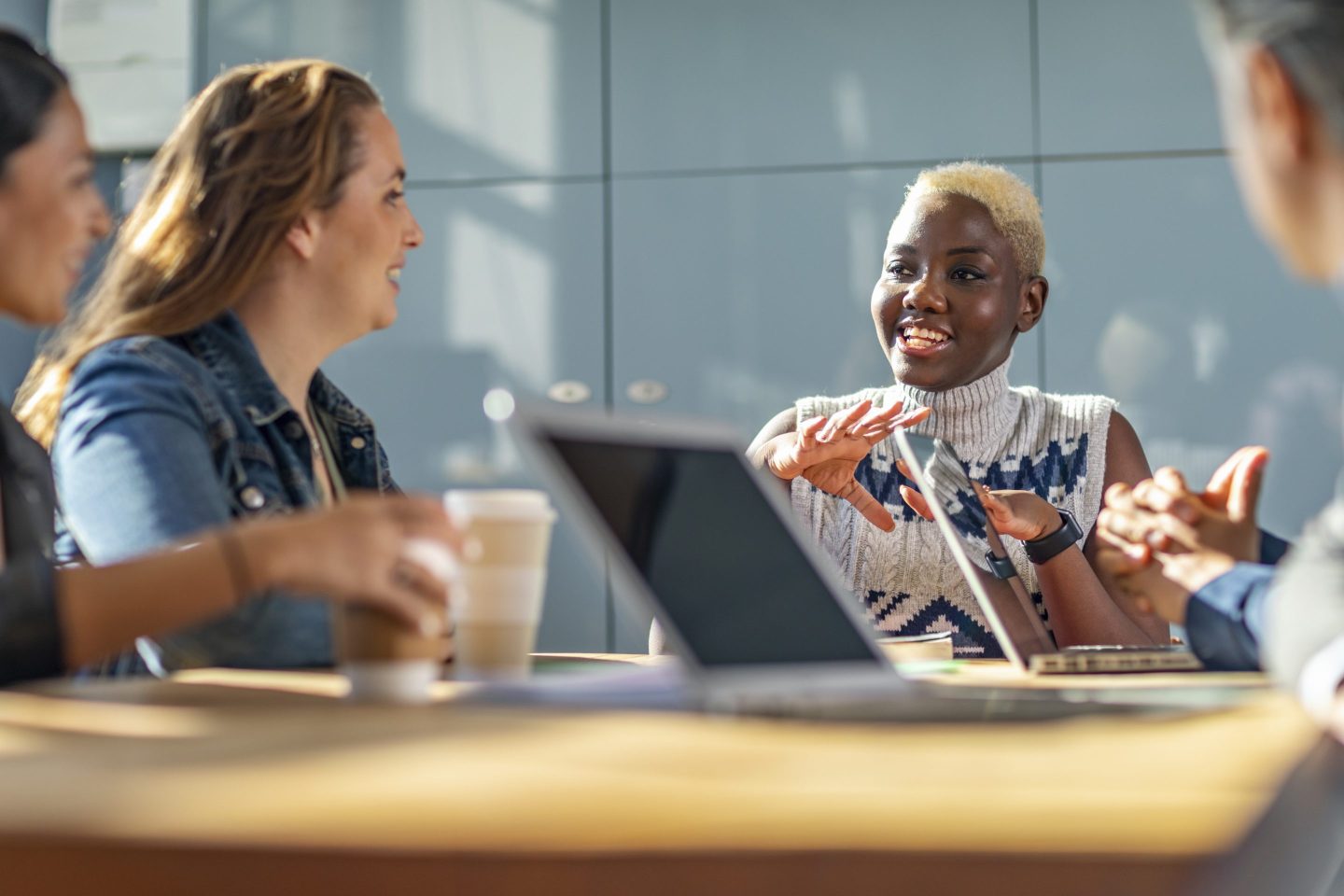 A young woman talks to co-workers at a desk