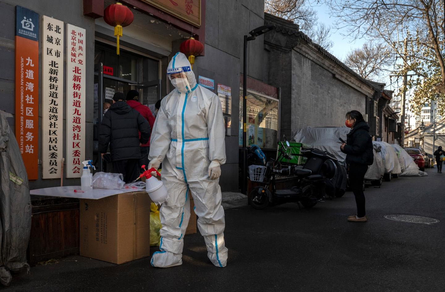 An epidemic control worker wears PPE as he sanitizes an area outside a local health office in China.