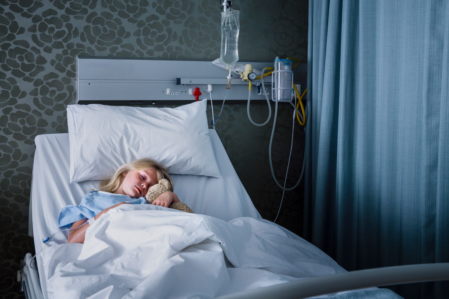 A little girl in a hospital bed.
