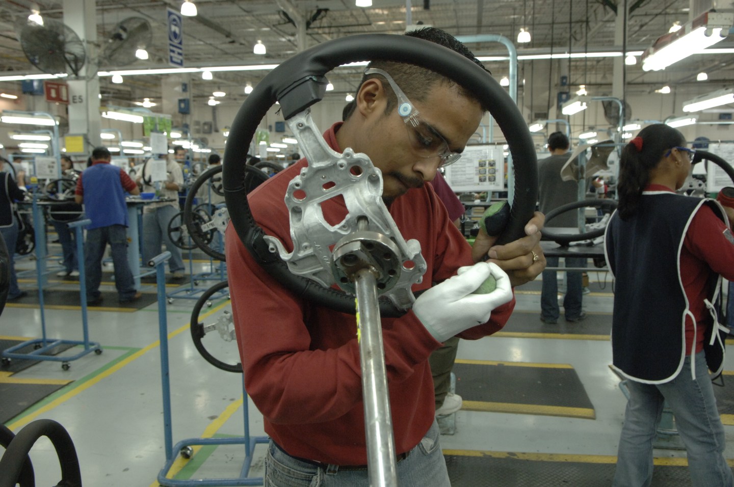 Man working on car parts in an assembly plant in Mexico