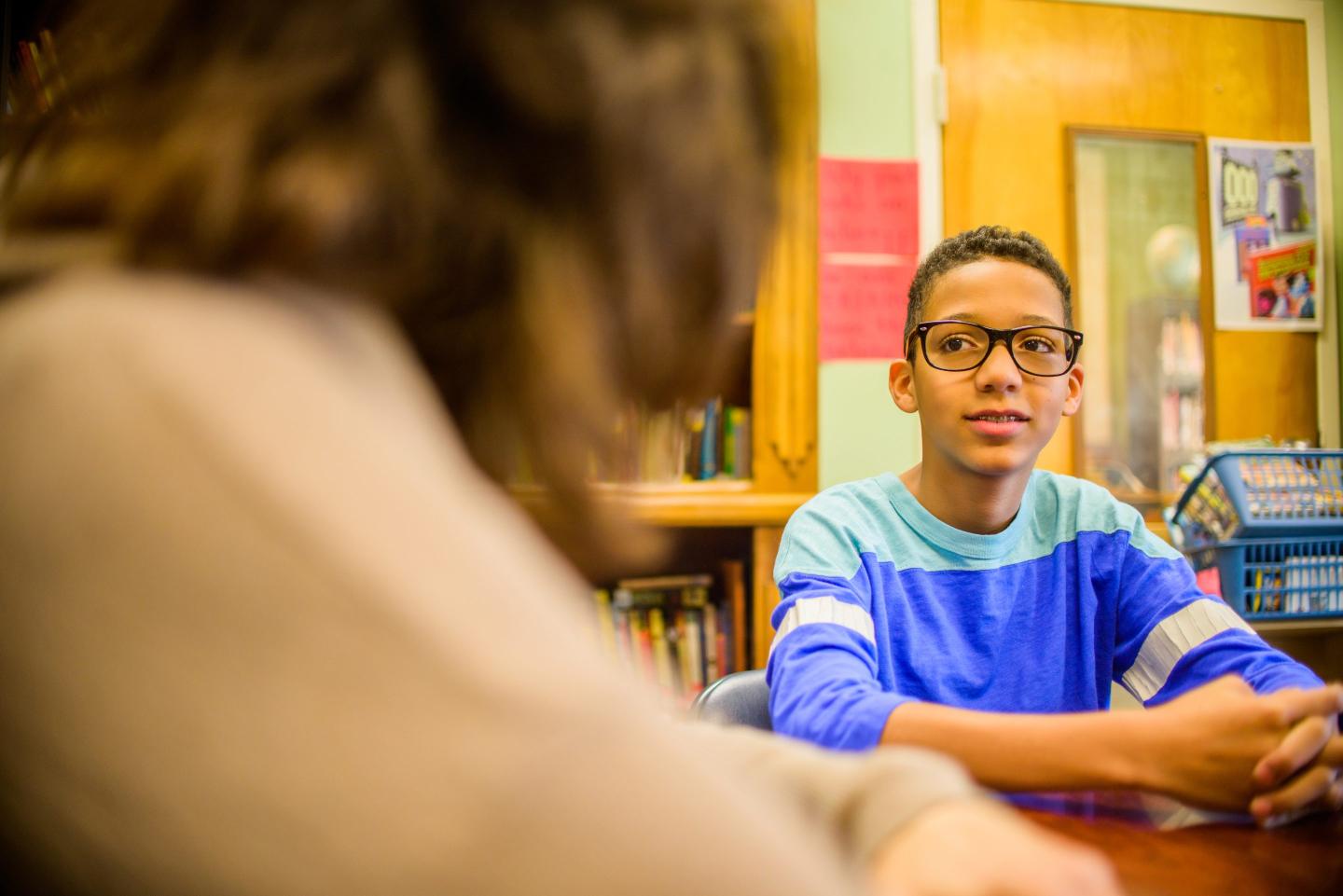 Teenage boy at school speaking to guidance counselor