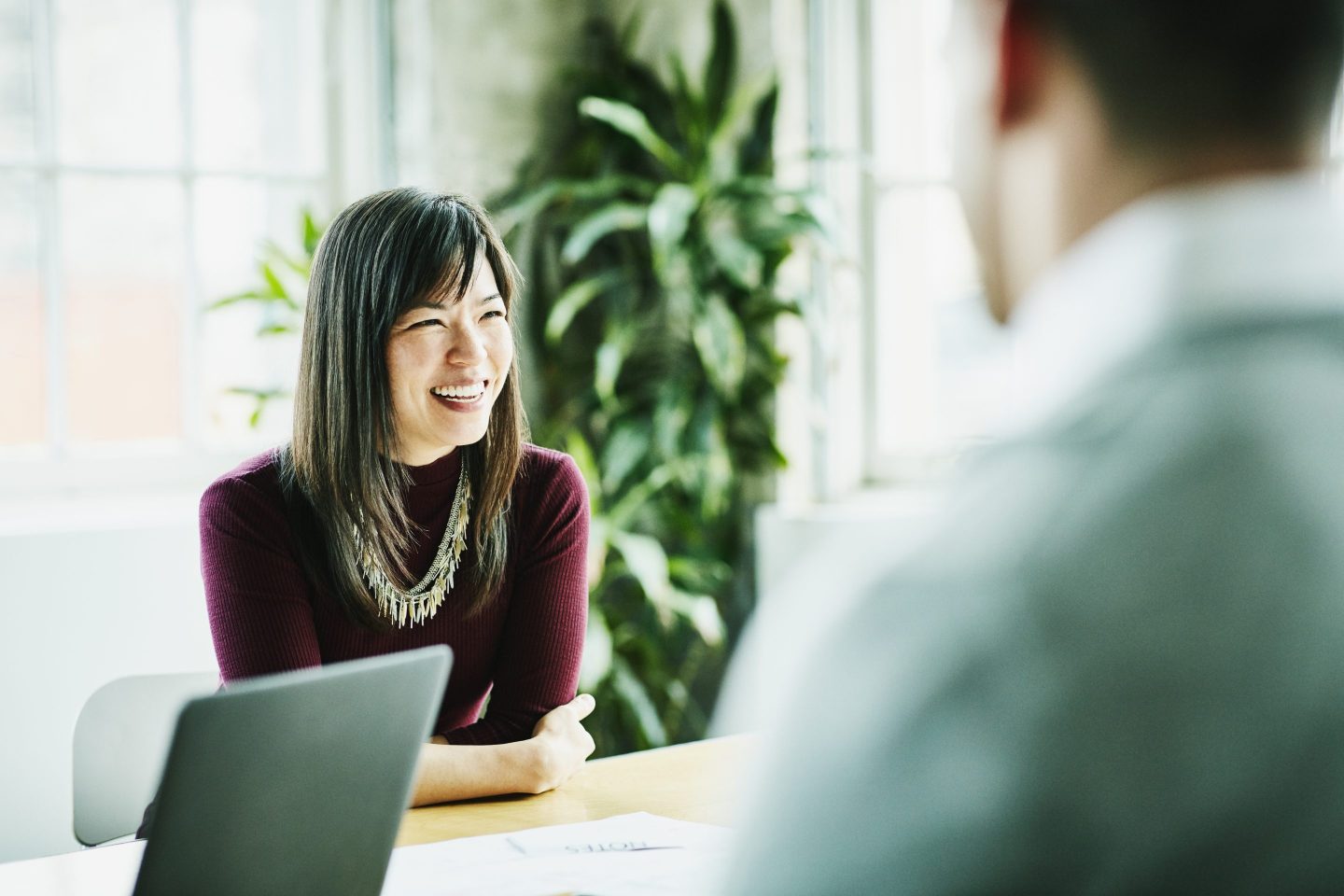 Smiling businesswoman leading project meeting in office conference room