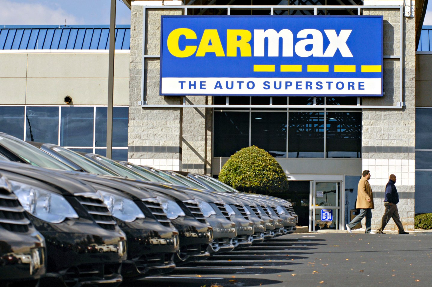 A customer walks past a Carmax.