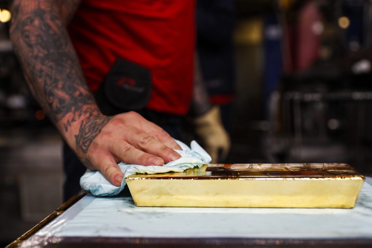 A worker uses a cloth to dry a freshly cast 12.5 kilogram gold bullion bar at the Valcambi SA precious metal refinery in Lugano, Switzerland, on Monday, April 24, 2018.