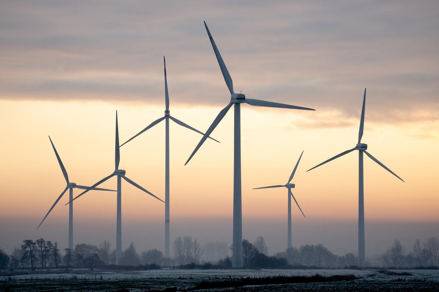 Wind turbines stand in winter weather.