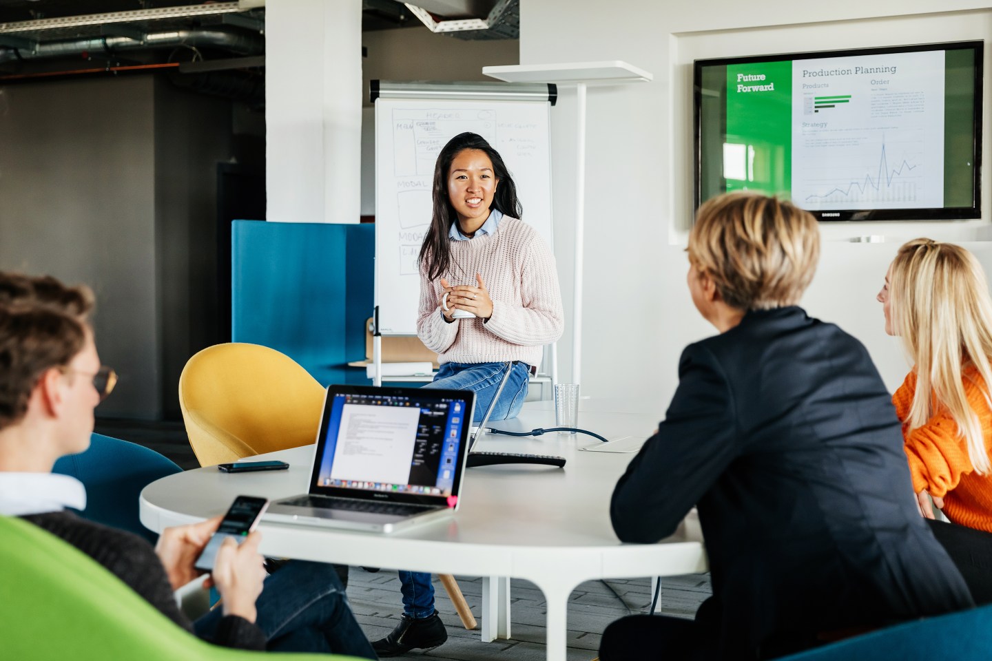 Employees listening to a colleague's presentation in the office
