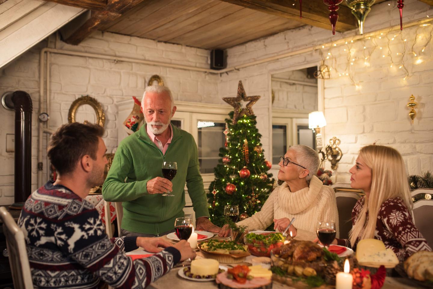 Man drinking wine and looking at his family